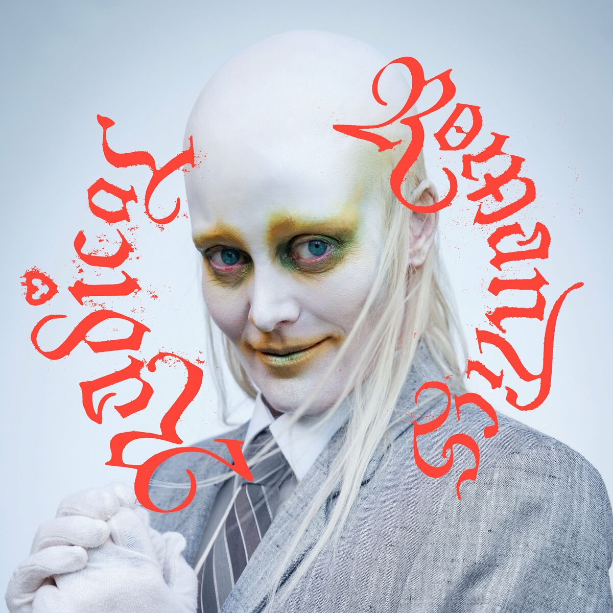 La copertina di Radical Romantics di Fever Ray, con il ritratto di lei che indossa una maschera e un trucco un po' inquietanti e un vestito da uomo. Intorno al suo viso c'è scritto Radical Romantics in rosso