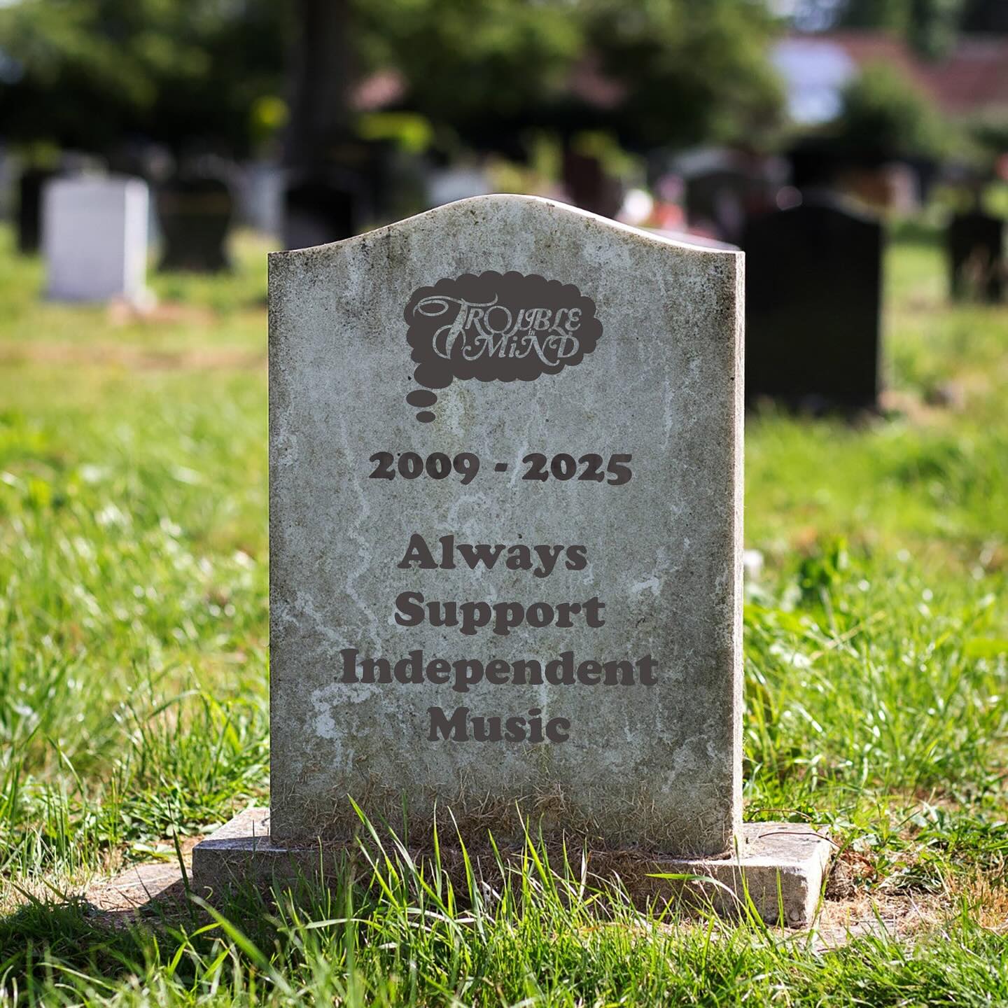 Una lapide immaginaria grigia su un prato verde sulla quale è inciso il logo della Trouble in Mind, e sotto «2009-2025»; ancora più sotto, c'è scritto «Always Support Independent Music»